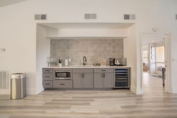 a kitchen with gray cabinets and a wood floor